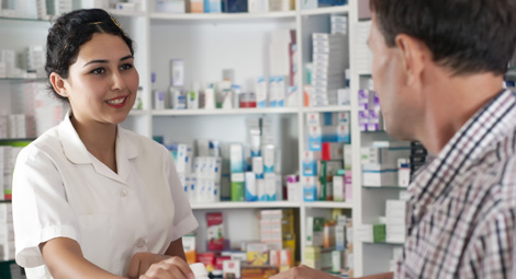 Female pharmacist dispensing a prescription to a male client